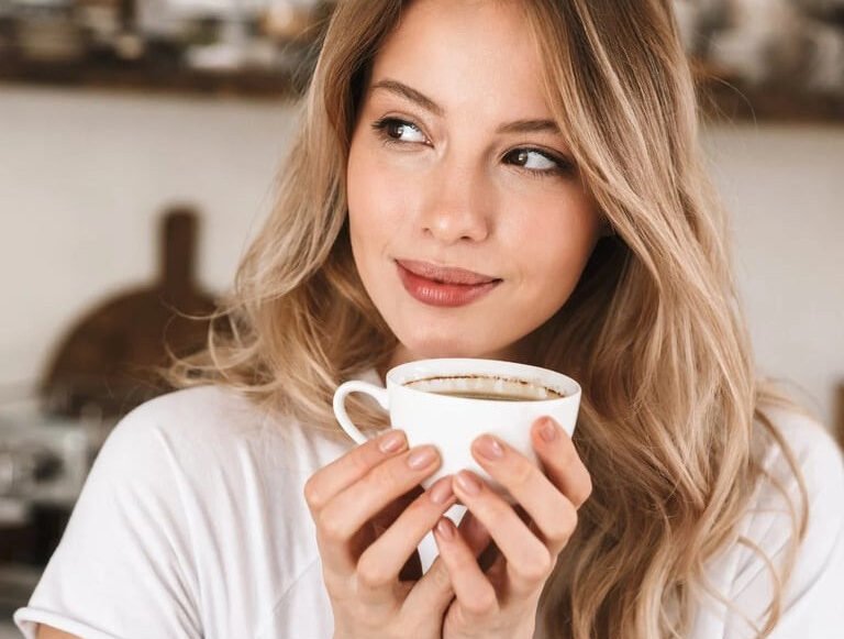 Mulher jovem apreciando uma xícara de café